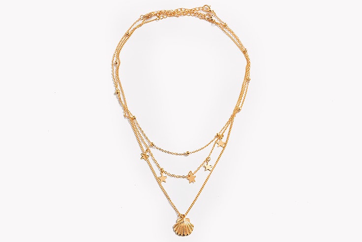 Colgante dorado con concha y estrellas de Paco Martínez